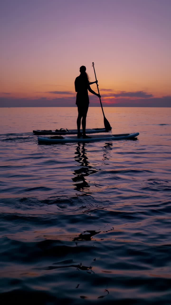 Silhouette of a Person Paddleboarding at Sunset