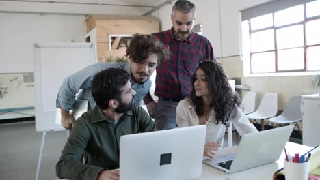 Group-of-cheerful-colleagues-sharing-ideas-with-each-other