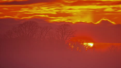 tiro de lapso de tiempo del sol saliendo detrás del cielo ardiente con nubes en la mañana, cerca - hermosa escena de la naturaleza durante el otoño