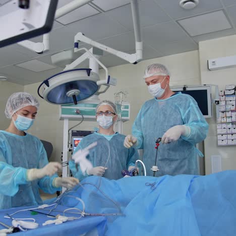 team of surgeons doing operation. surgeon hands holding special medical instruments during laparoscopic surgery