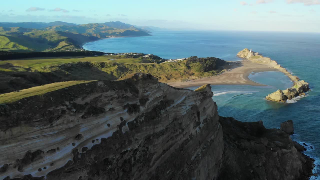 뉴질랜드 와이라라파 해안 의 아름다운 캐슬포인트 해변 과 등대 를 내려다보는  ⁇ 리버런스 코브 트랙 꼭대기 에 서 있는 사람