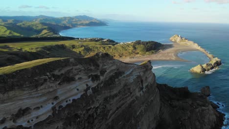 Persona-De-Pie-En-La-Parte-Superior-De-La-Pista-De-La-Ensenada-De-La-Liberación-Con-Vistas-A-La-Hermosa-Playa-De-Castlepoint-Y-Al-Faro-En-La-Costa-De-Wairarapa,-Nueva-Zelanda