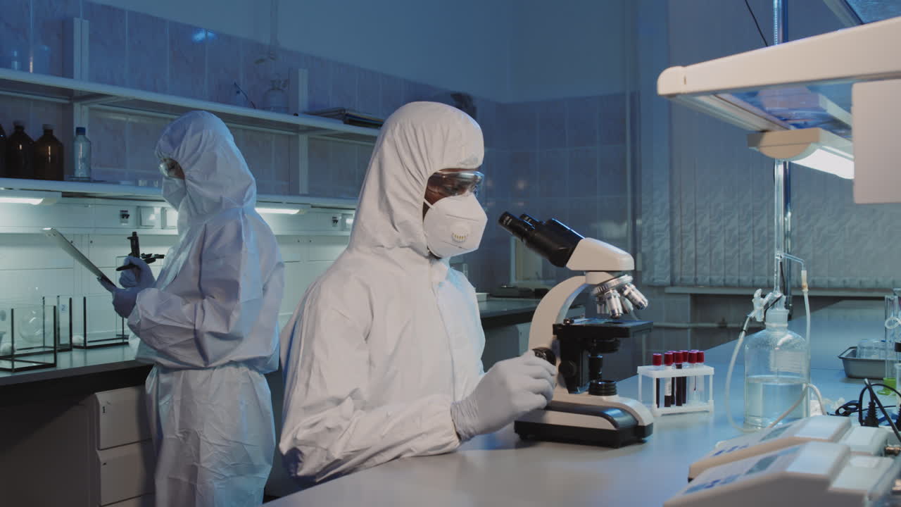 Epidemiologo che usa il microscopio in laboratorio