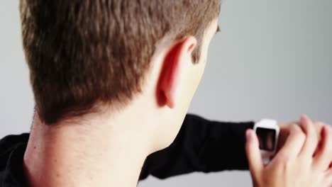 androgynous man using smartwatch