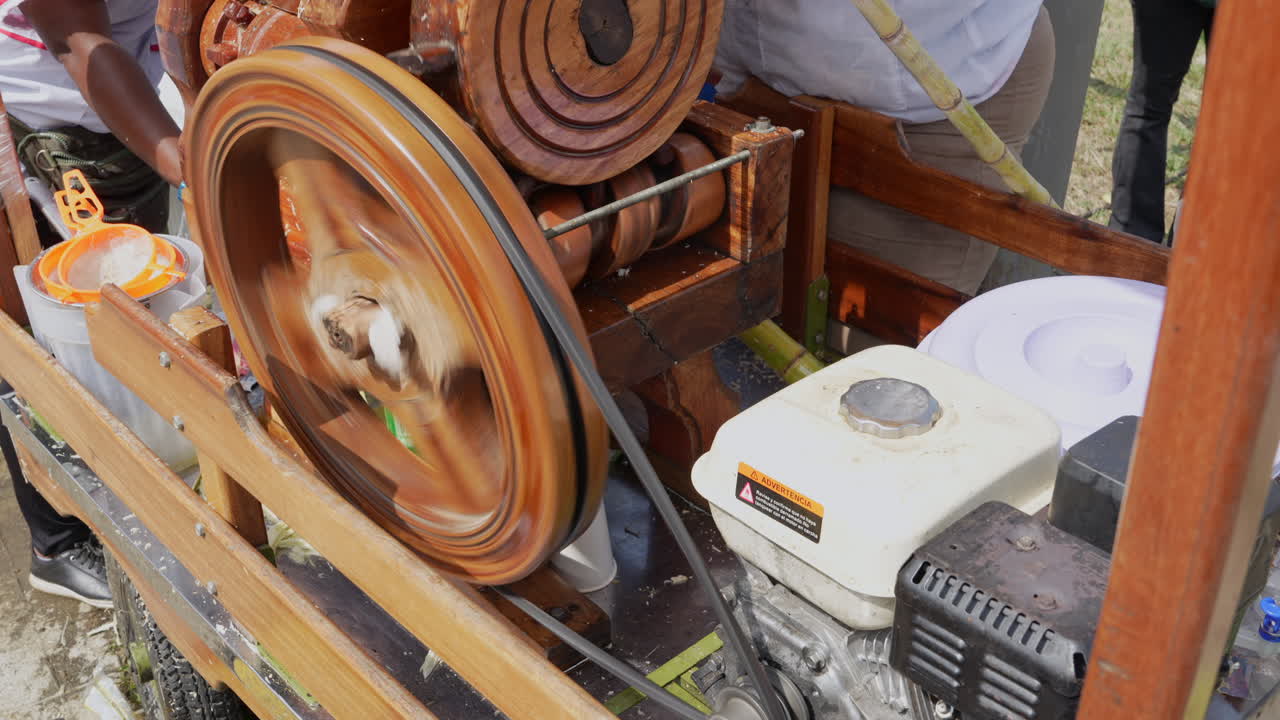 Close-up of a vibrant, rustic sugar cane juicing machine in action. Dynamic motion with spinning wheels and gears, capturing the essence of traditional agriculture on a sunny day