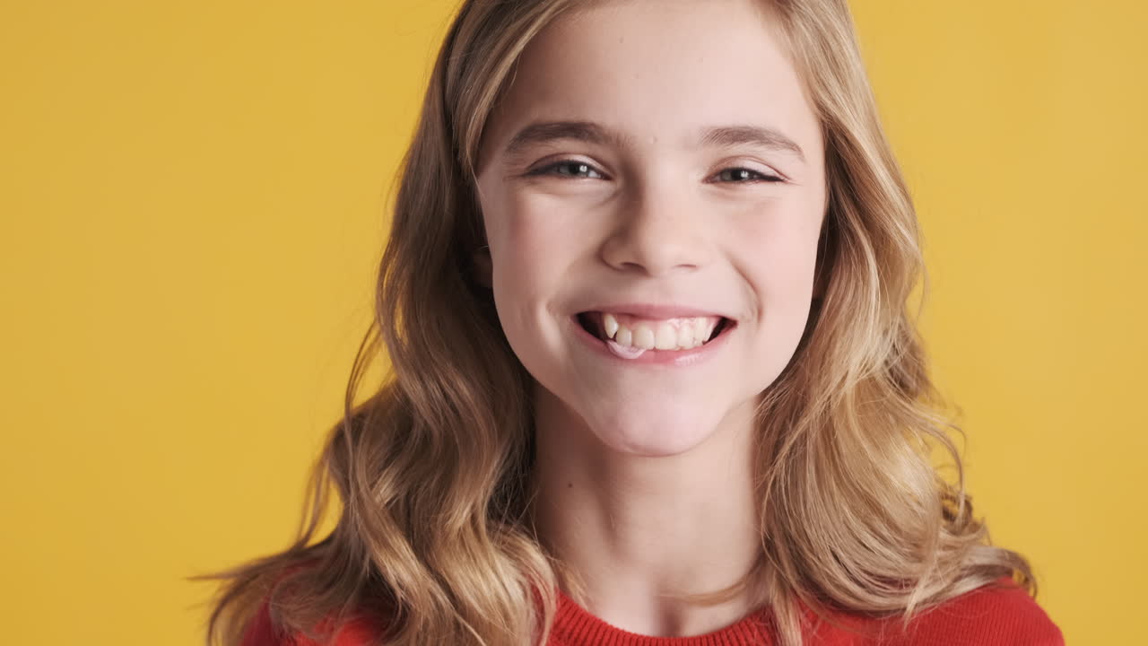 кавказская девушка-подросток жует жевательную резинку и продувает пузырьки.