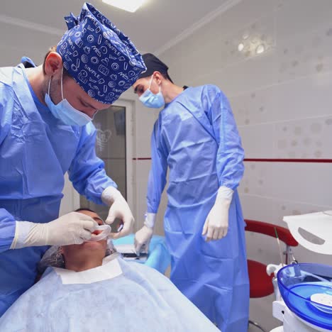 dentist is treating a patient in a modern dental office. stomatologist prepares woman's mouth before the tooth treatment. dentistry concept.