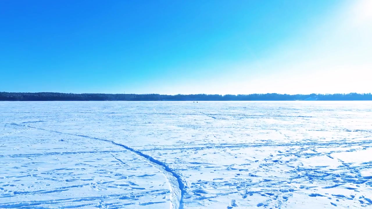 Blick aus geringer Höhe über offener, verschneiter Wüstenlandschaft, heller Himmel
