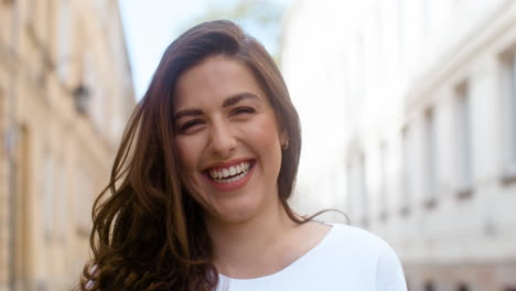 Portrait-Of-A-Beautiful-Woman-Laughing-And-Looking-At-Camera-In-The-Old-Town-Street