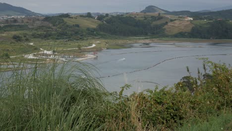 Peaceful view of Ría San Martín, Suances, with green hills and calm water