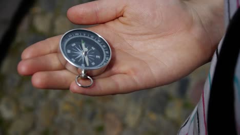 young woman takes out a compass and adjusts it