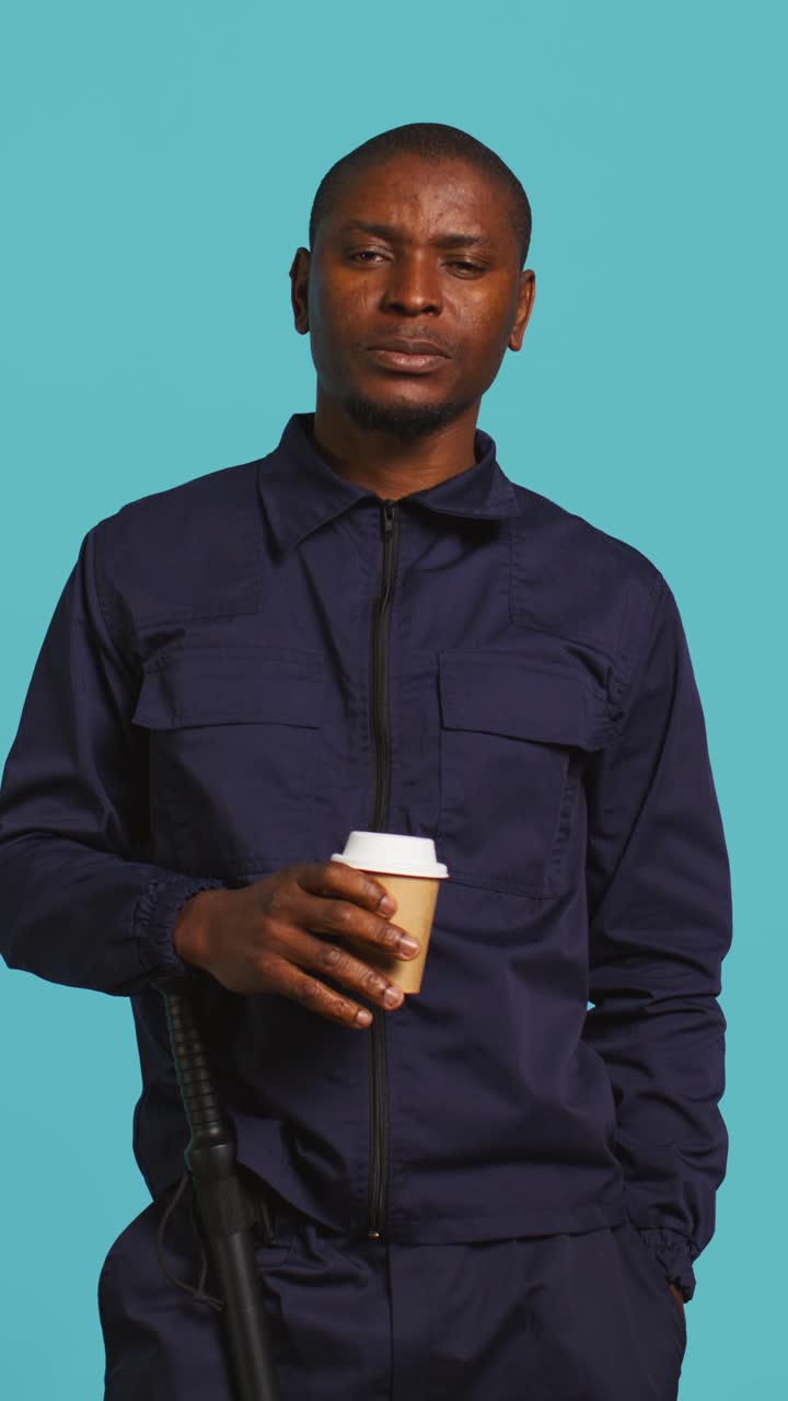 Træt afroamerikansk mand, der drikker kaffe og gaber