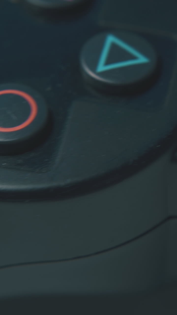modern joystick with different symbols on buttons for playing video games on white surface macro