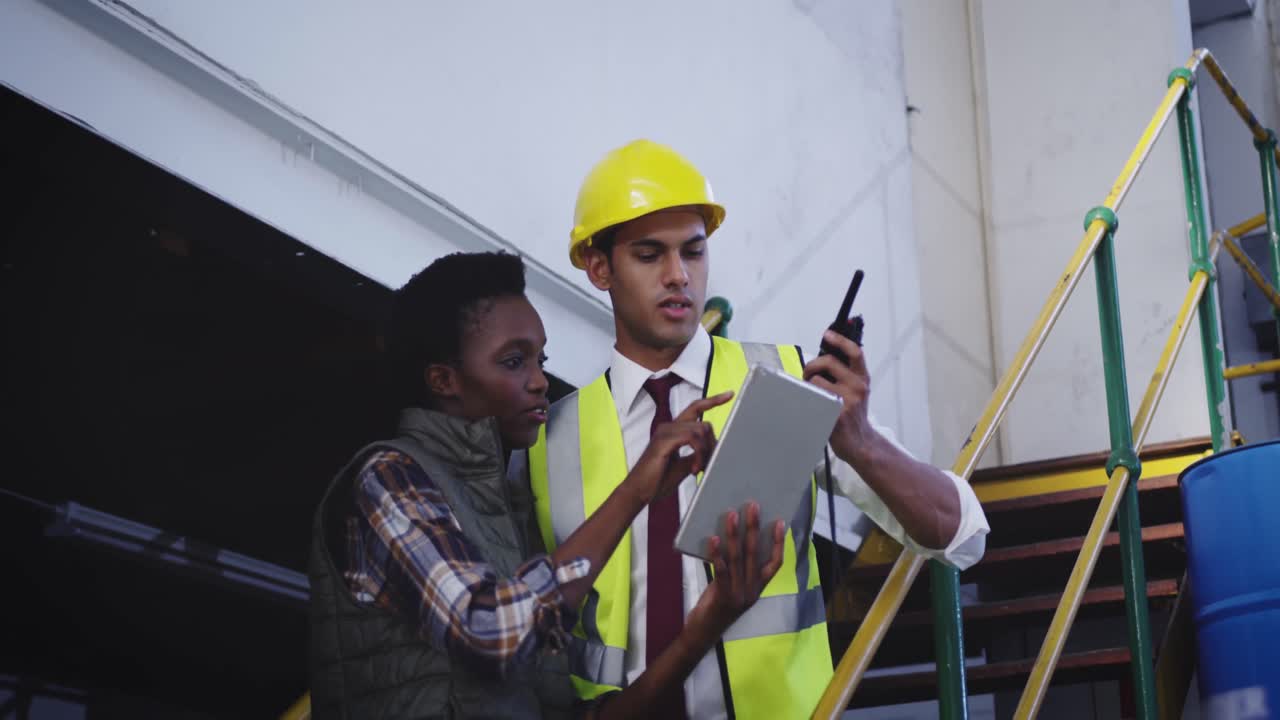 dos trabajadores de almacén hablando en las escaleras en un almacén 4k