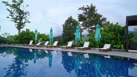 piscina de cama alrededor de la piscina con fondo de colina de montaña