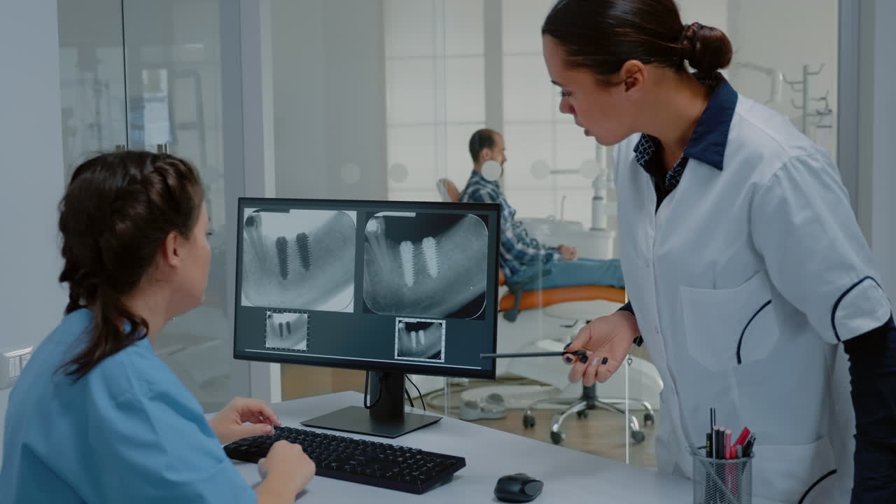 estomatólogo y enfermera que examina la radiografía dental