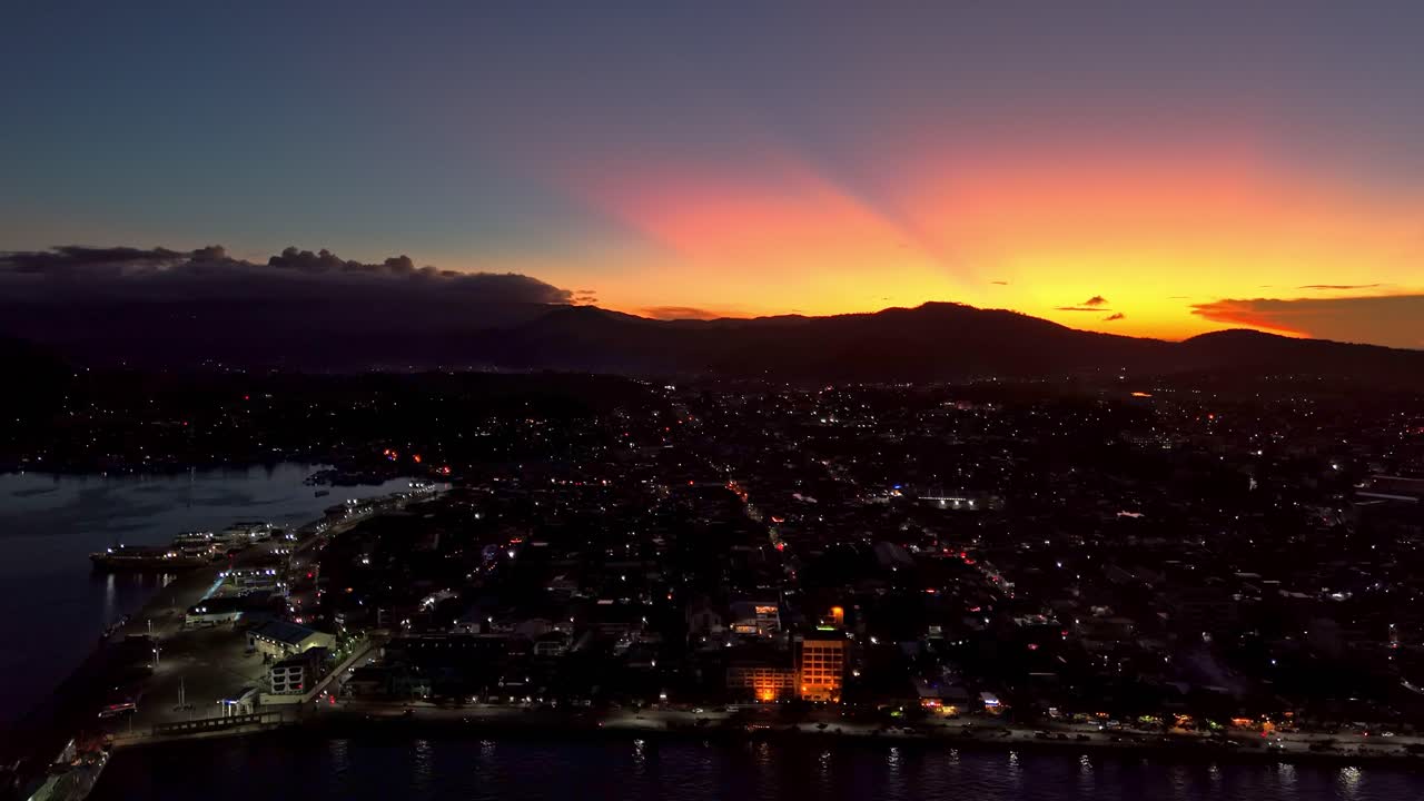 resplandor iluminado del atardecer sobre la ciudad de surigao con luces de la ciudad por la noche