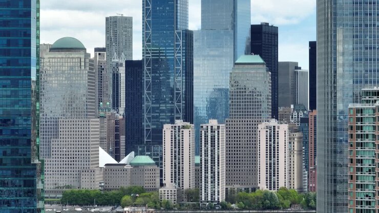 Imagem aérea com zoom longo e fechado de arranha-céus na Baixa Manhattan, no distrito financeiro.