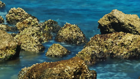 surf at the rocks - red stone on a background of blue sea 4k timelapse video