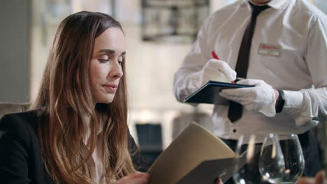 business woman choosing food menu in restaurant. woman ordering dinner in cafe