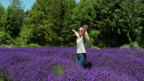 Mujer-Joven-Feliz-En-El-Campo-De-Lavanda-En-Wanaka,-Nueva-Zelanda,-Dando-Vueltas-Con-Los-Brazos-Abiertos-En-Un-Día-Soleado