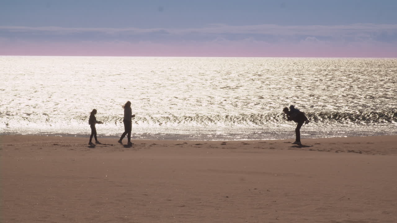 해가 지는 해변에서 가족들이 어울리는 모습