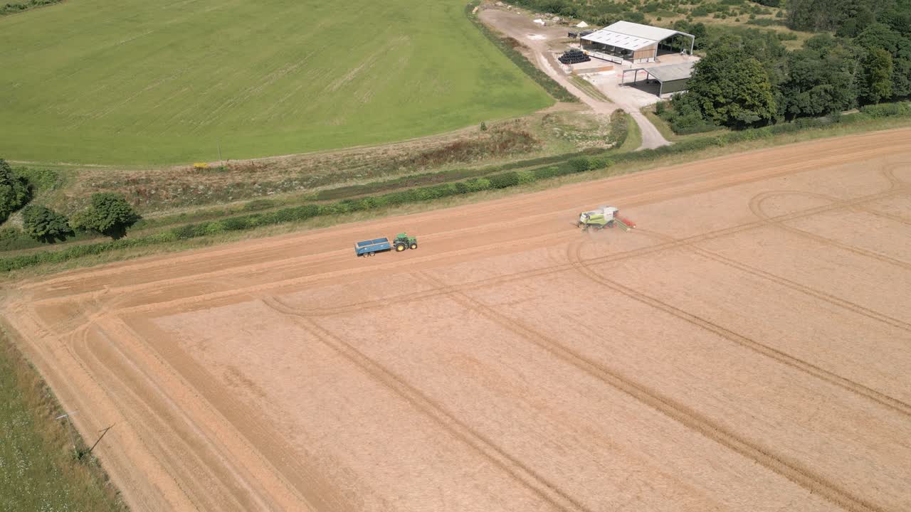 Combine Harvester Harvesting Cereal Crops On The Field In Wilton, Marlborough, United Kingdom. - aerial shot
