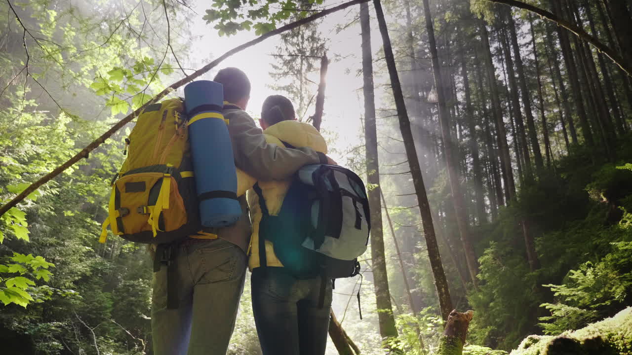 una pareja joven camina por un sendero panorámico en el bosque