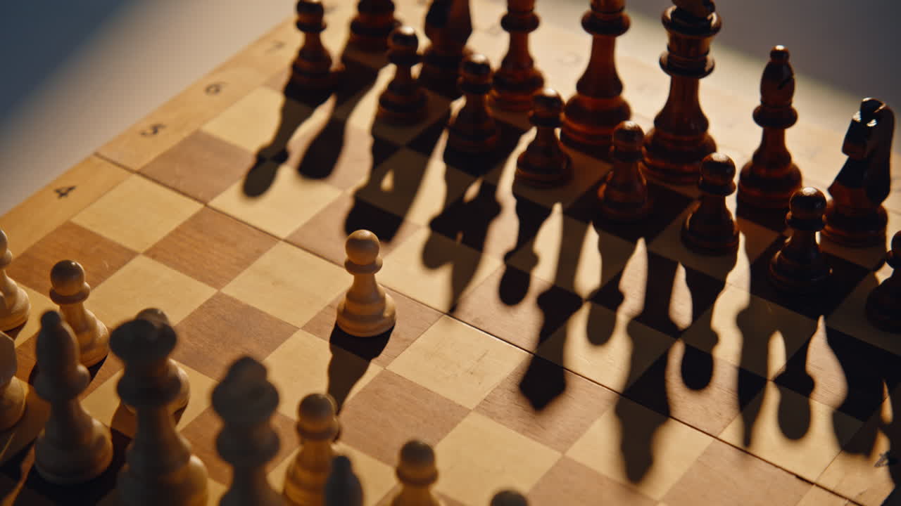 Fingers pushing initial figure on patterned board with shadows. Player starting