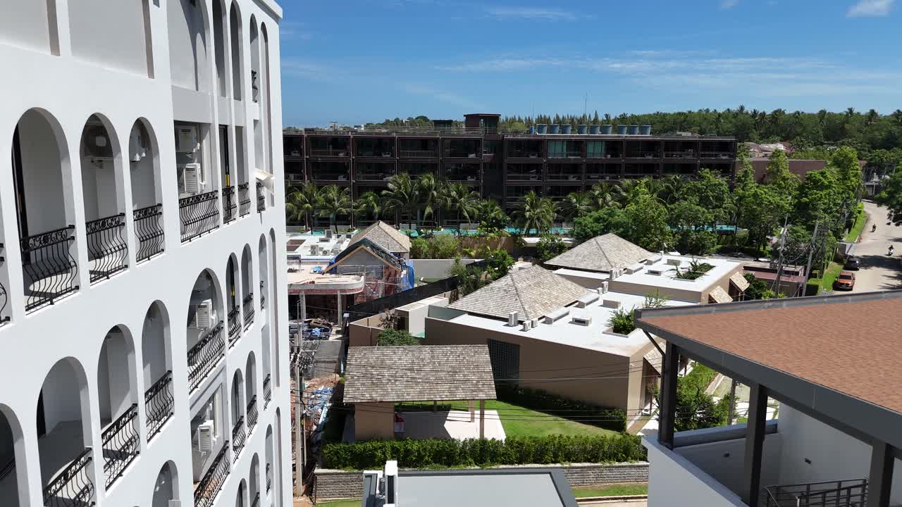 Cityscape view of modern buildings with construction and palm trees under a clear blue sky