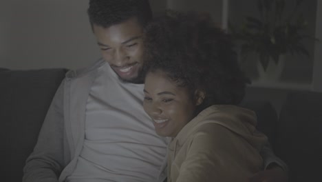 young african american couple choosing a movie to watch on the laptop