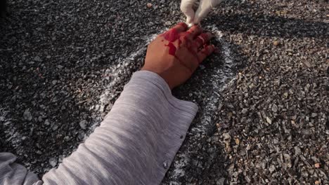 Handheld-Close-up-shot-of-hands-marking-or-outlining-the-dead-body-with-chalk