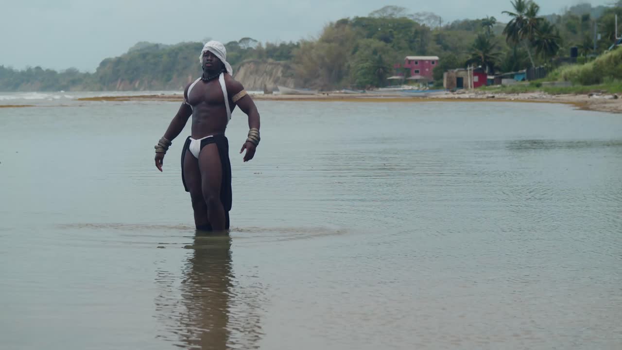 A male cosplayer, dark-skinned and muscular, by the sea.