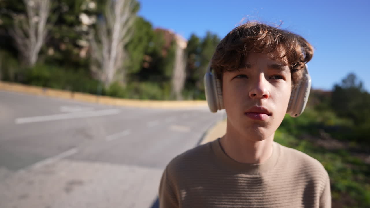 Teenager with Headphones Walking on Road