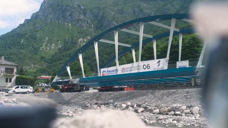 bridge construction site in scenic tende with heavy rigging, set against a mountain backdrop