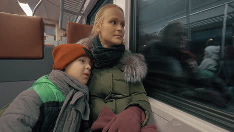 mother and her gentle loving son traveling by train