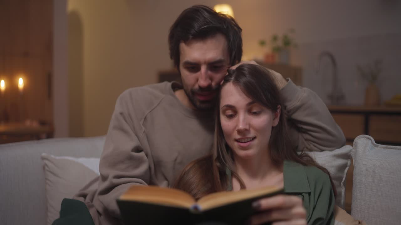 pareja leyendo un libro en casa