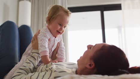 Kaukasische-Mutter-Lächelt,-Während-Sie-Zu-Hause-Mit-Ihrem-Baby-Auf-Dem-Bett-Spielt