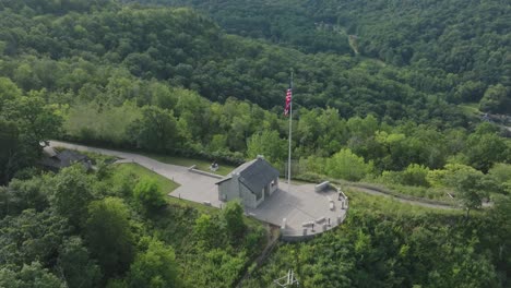 american flag on hilltop overlooking lush greenery