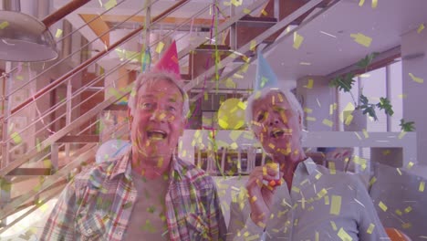 happy caucasian senior couple in party hats making birthday video call, with gold confetti