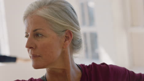 close up portrait beautiful old woman exercising yoga class meditation practicing warrior pose enjoying group physical fitness workout in studio