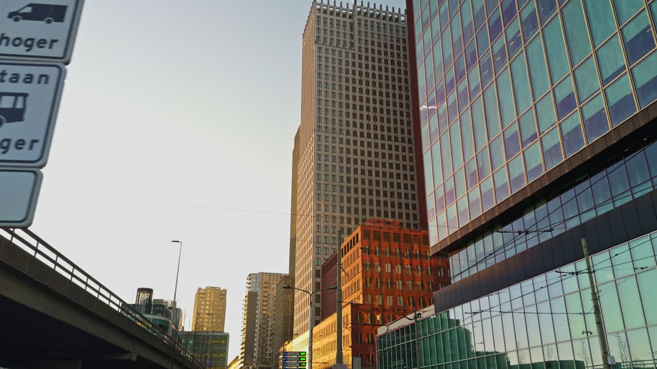 Strada di una moderna città europea nei Paesi Bassi, all'Aia, con edifici e grattacieli durante l'ora d'oro della prima serata, poco prima del tramonto, ampia visuale dal basso