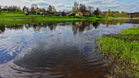 serene river landscape with village and fishing net