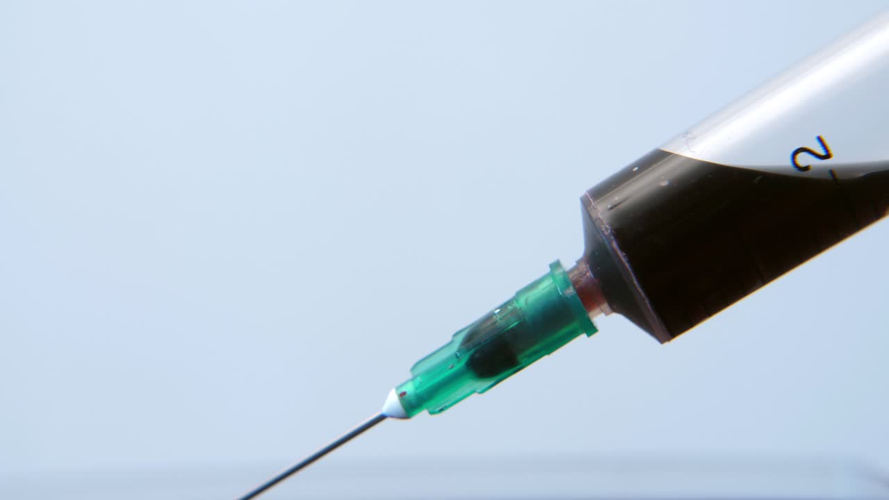 Close Up of Syringe Filling with Dark Red Liquid