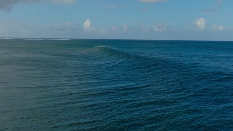 slow motion drone shot of a wave breaking at one eye, mauritius