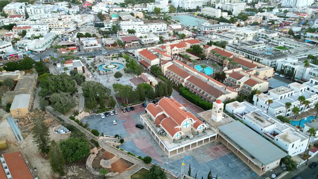 Aerial View Of Ayia Napa Monastery And Fountain Central Square In Ayia Napa, Cyprus. Amusement Park And Seascape Revealed. orbiting shot