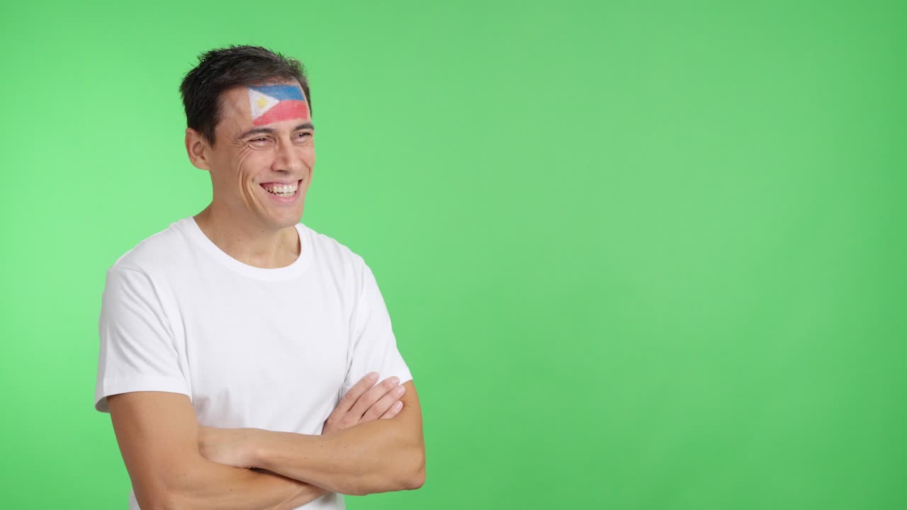 Happy man with philippine flag painted on face looking away
