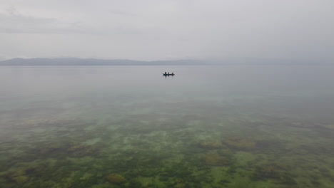 Aerial-footage-flying-towards-an-outrigger-boat-in-Cebu-Philippines,-close-to-the-water-surface,-Drone,-Cinematic