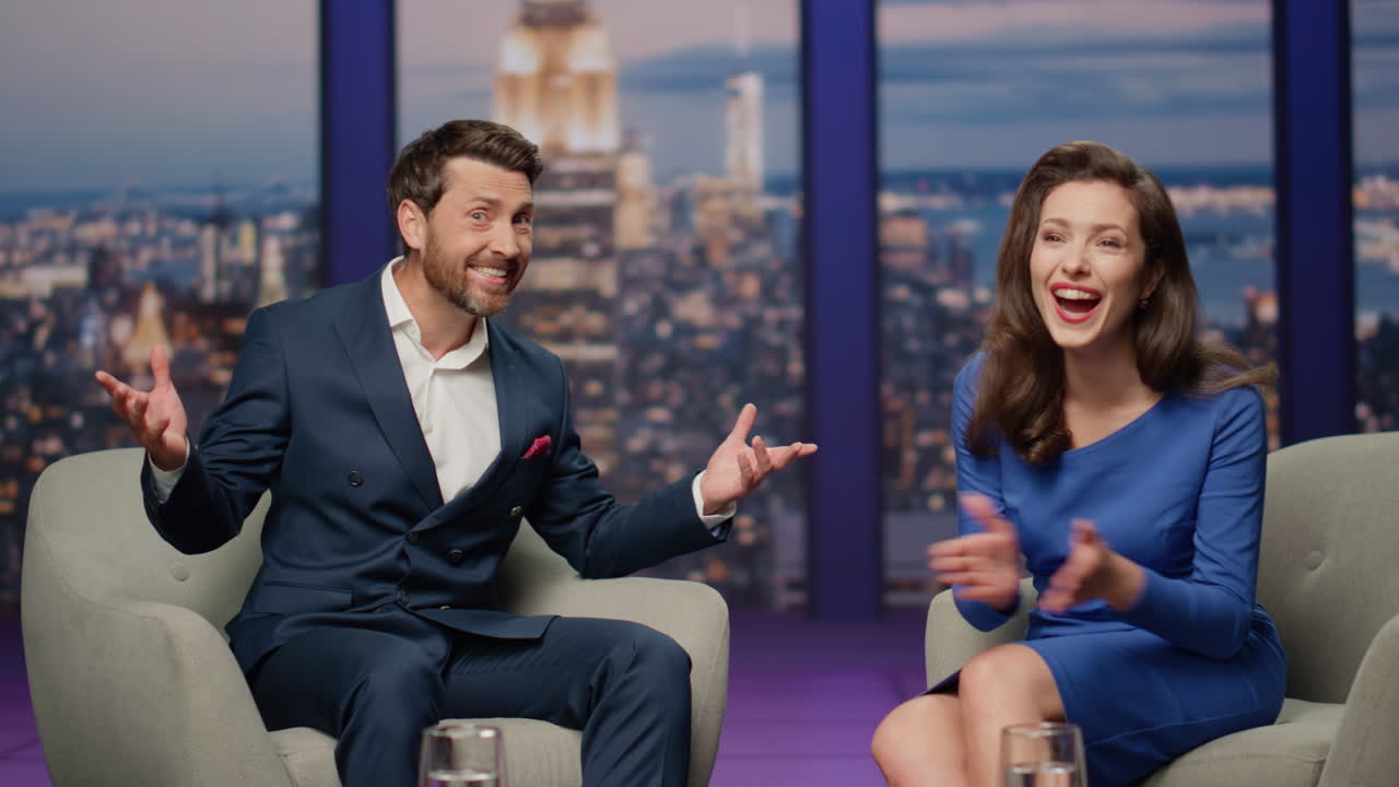 Talk show guest sharing success to audience sitting television studio with host.