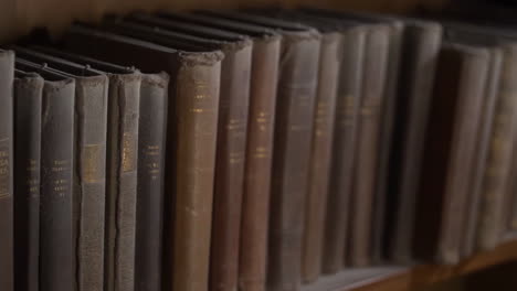 row of old books on a wooden shelf